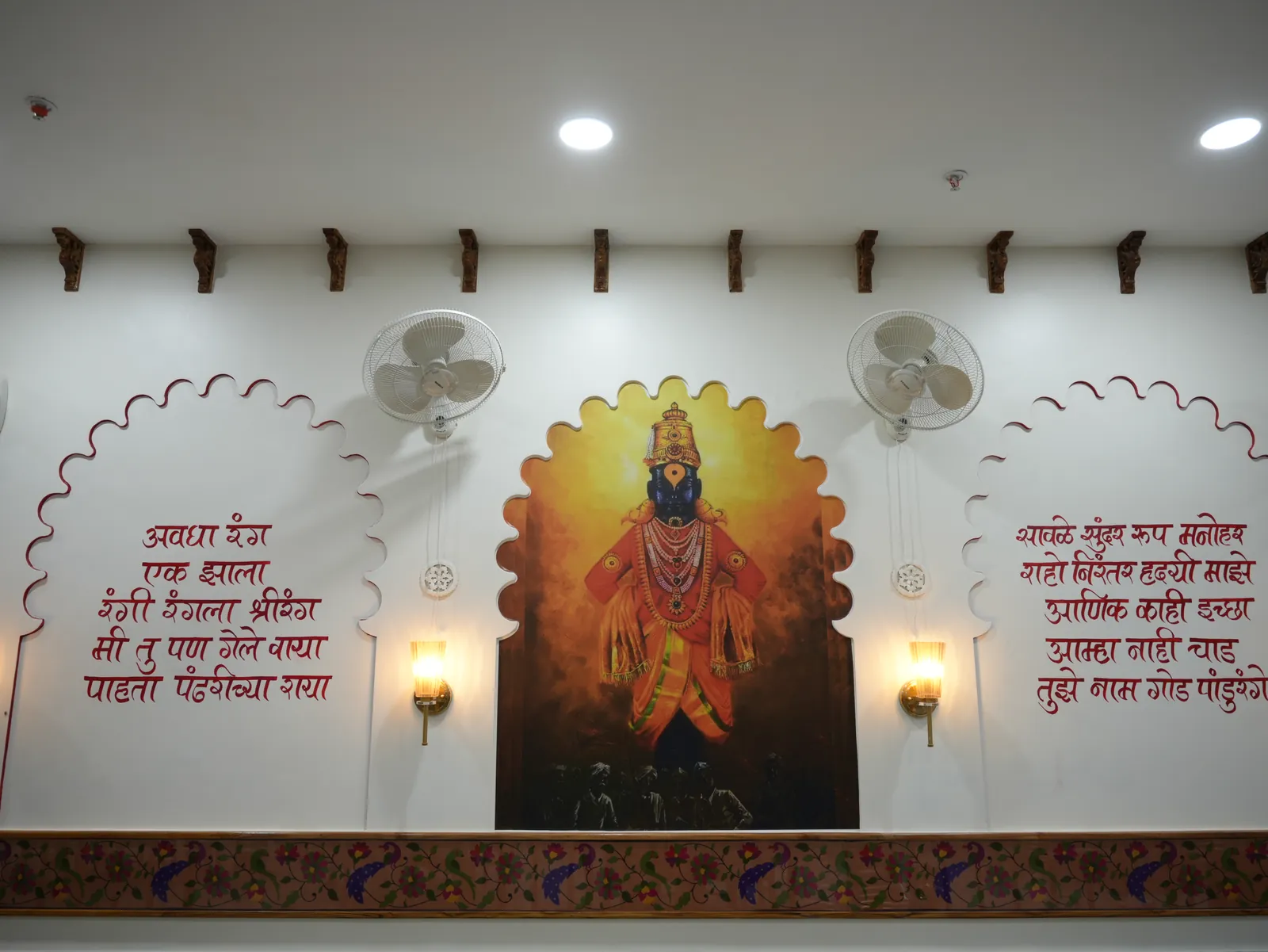 Devotional wall artwork, Marathi lettering and warm lamps.