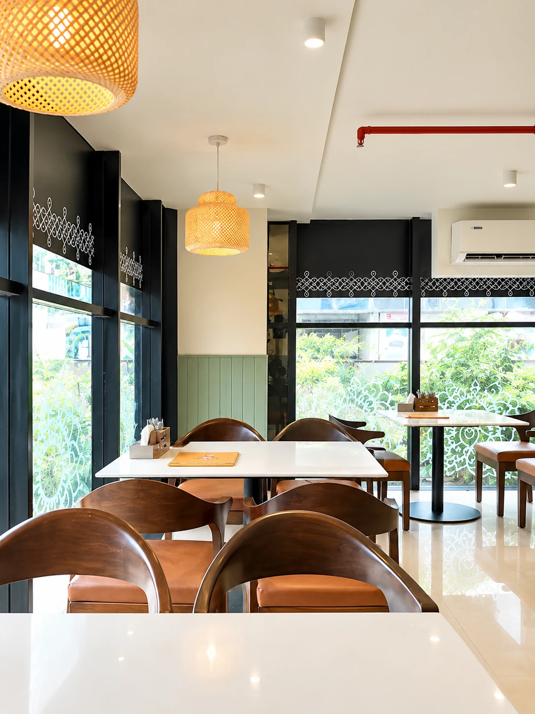 Window-side café tables beneath woven pendant lights.