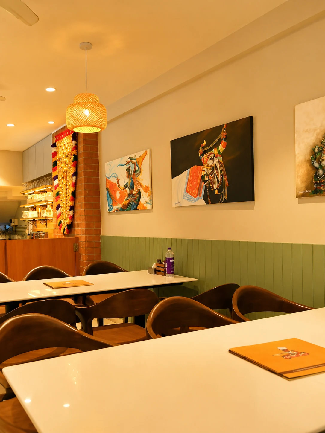 Pale tabletops and curved-back chairs beside the café art wall.
