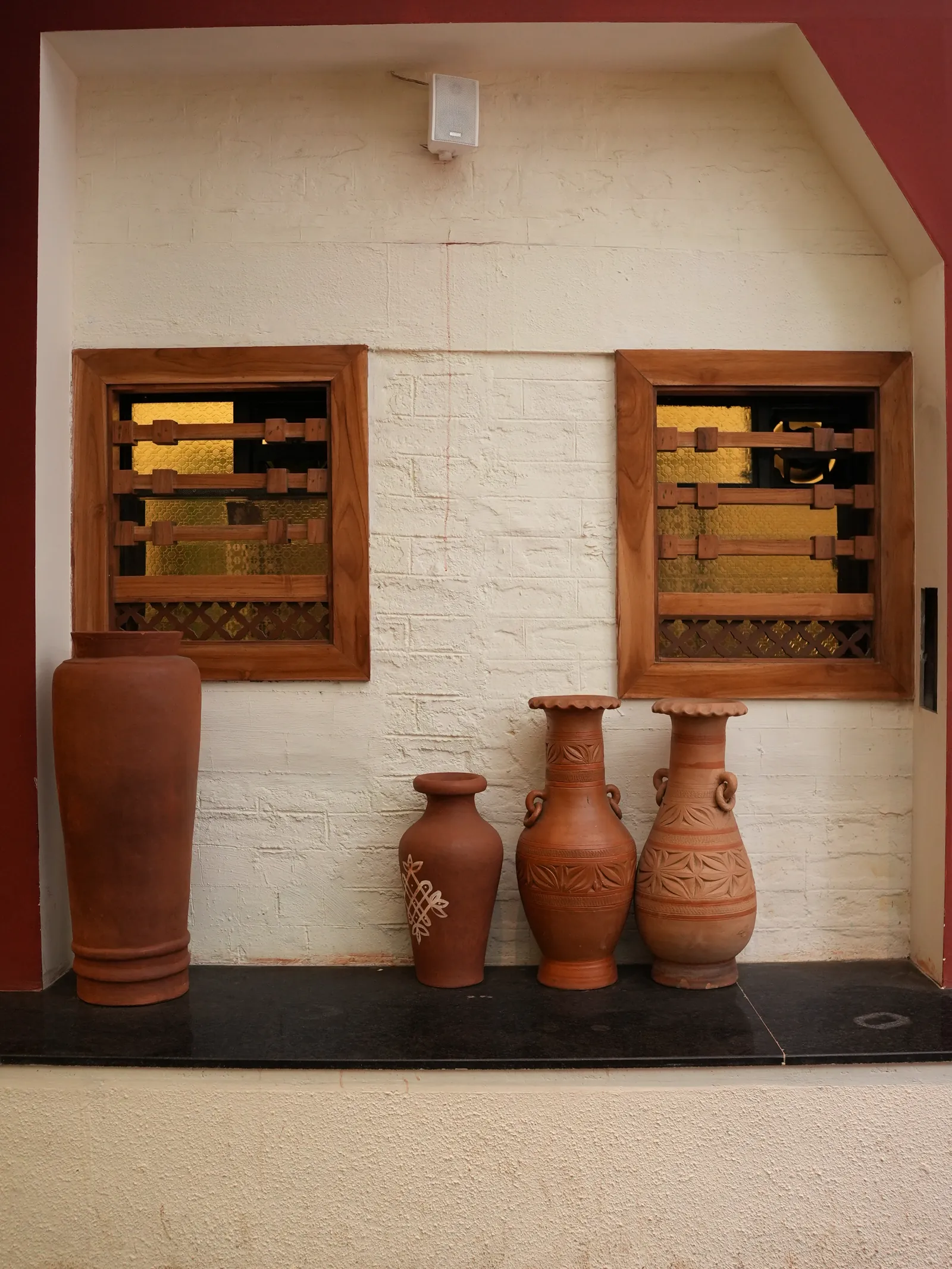 Earthen pots below timber-framed windows.
